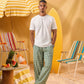 a man wearing a white tee and green and white checkered lounge pants