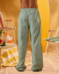 a man wearing a white tee and green and white checkered lounge pants