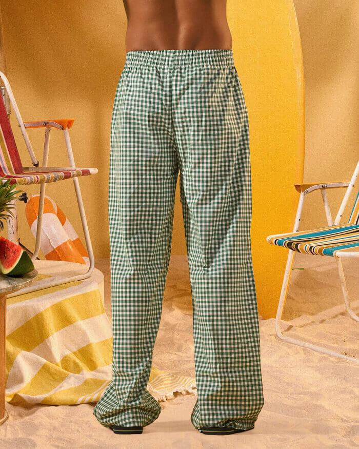 a man wearing a white tee and green and white checkered lounge pants