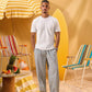 a man wearing a white tee and grey and white checkered lounge pants