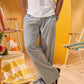 a man wearing a white tee and grey and white checkered lounge pants