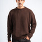 Man wearing a brown sweater against a white background