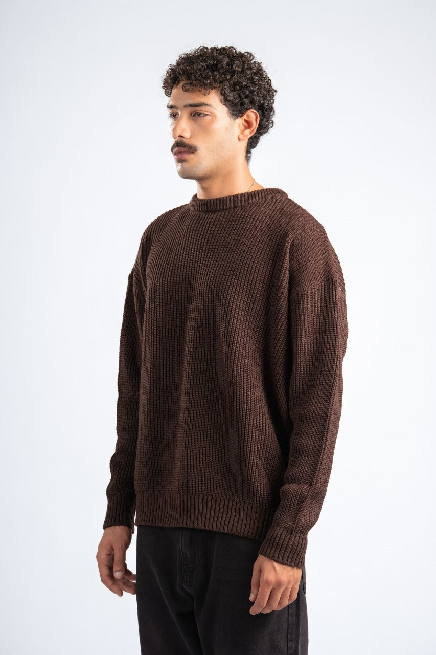 Man wearing a brown sweater against a white background