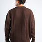 Man wearing a brown sweater against a white background