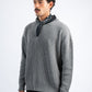 Man wearing a gray sweater with a black scarf around his neck on a white background