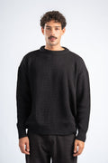 Man wearing a black sweater against a white background