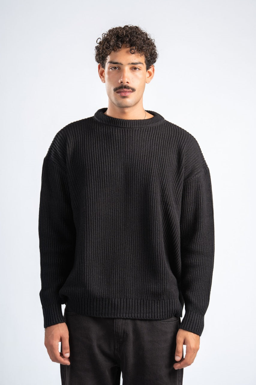 Man wearing a black sweater against a white background