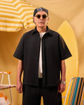 Man wearing sunglasses and a black shirt with a yellow background