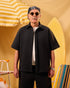 Man wearing sunglasses and a black shirt with a yellow background