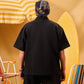 Person wearing a black shirt and cap with a yellow and white striped umbrella in the background
