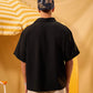 Person wearing a black shirt and camouflage cap against a yellow and white striped background