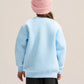 A child shown from the back wearing a light blue crewneck sweatshirt, a pink ribbed knit beanie, and black pants, set against a plain light beige studio background.