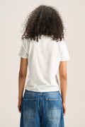 A person shown from the back wearing a plain white short-sleeve T-shirt and blue jeans against a light neutral studio background.
