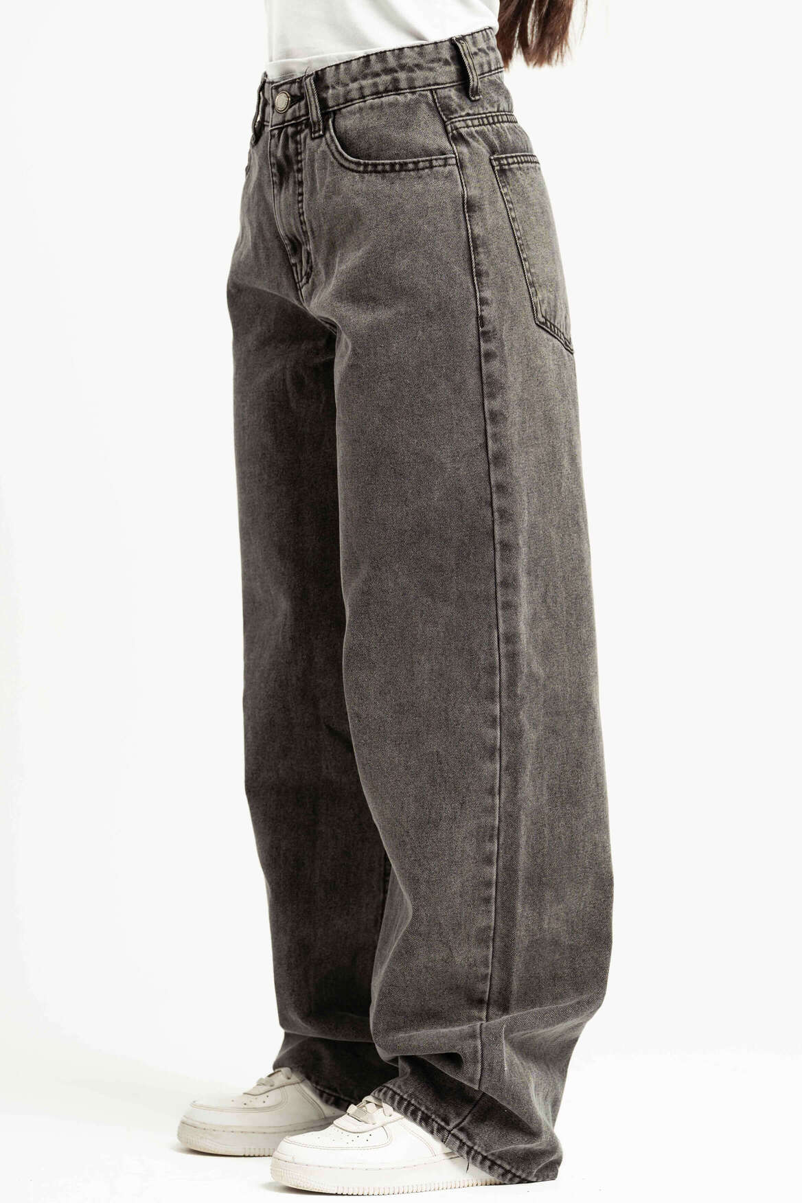 Gray jeans worn by a person on a white background