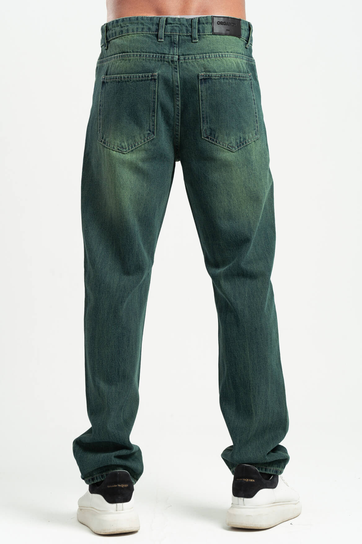 Green jeans worn by a person on a white background