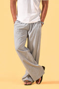 a man wearing a white tee and grey and white checkered lounge pants