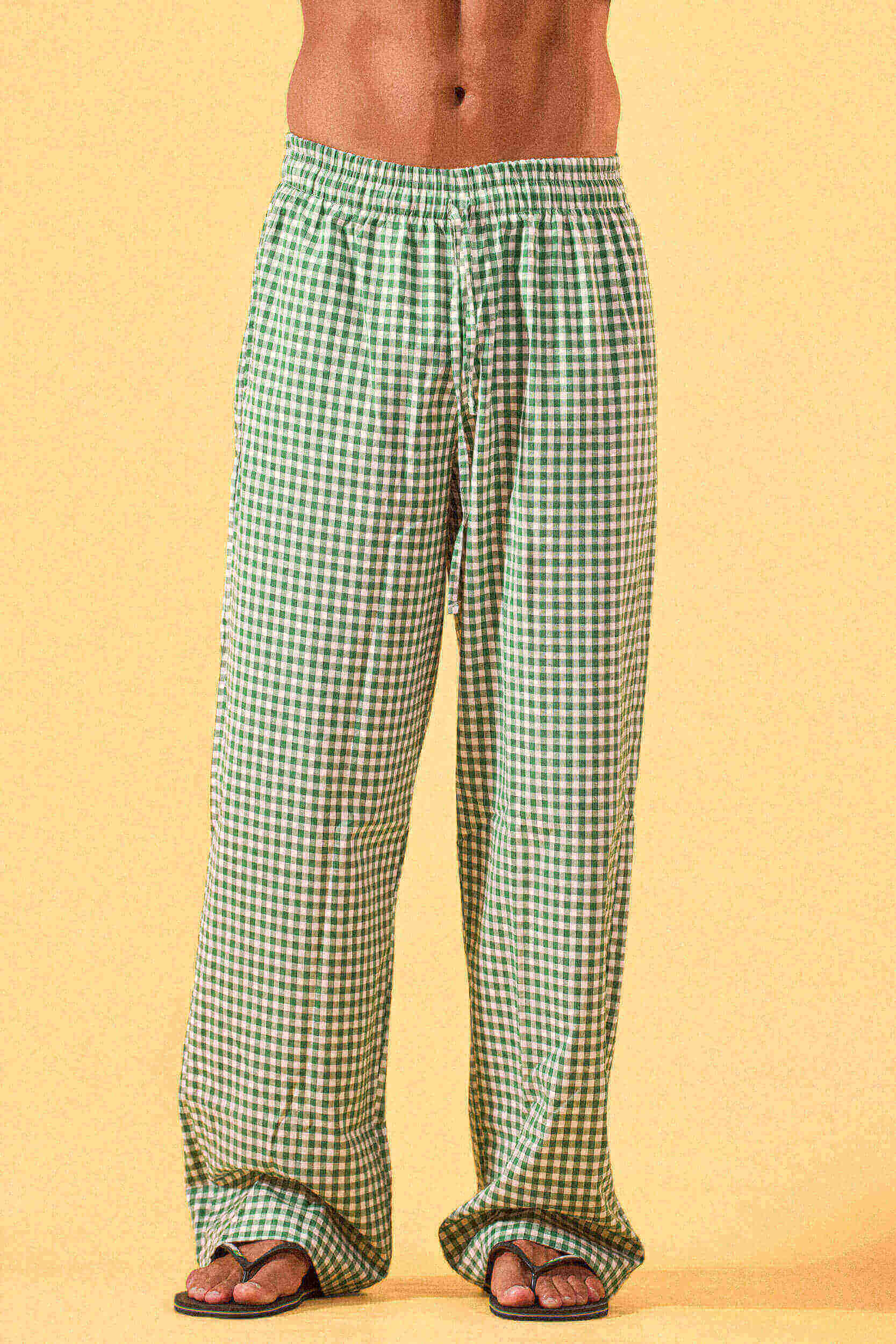 a man wearing a white tee and green and white checkered lounge pants