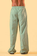 a man wearing a white tee and green and white checkered lounge pants