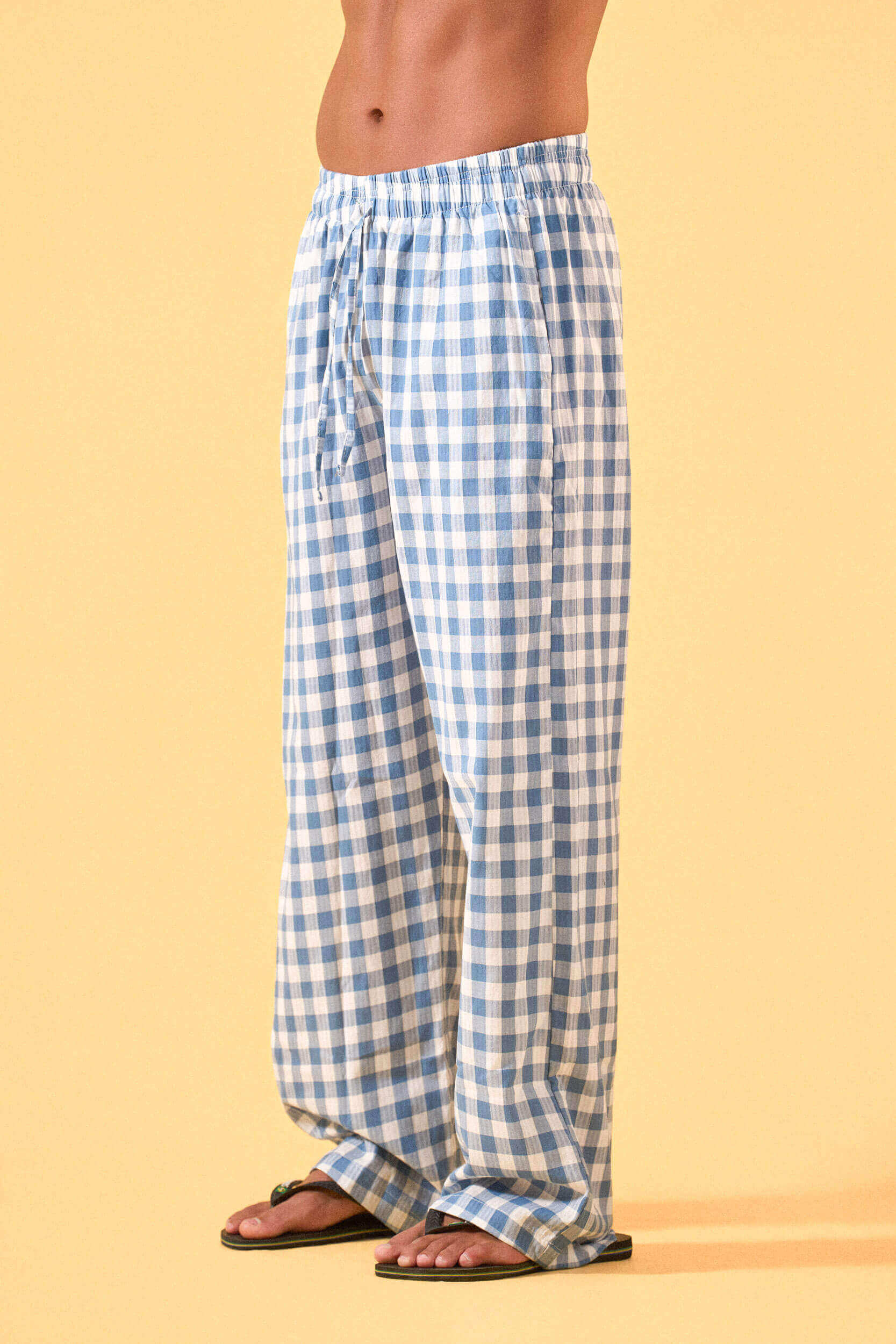 a man wearing a blue and white checkered lounge pants