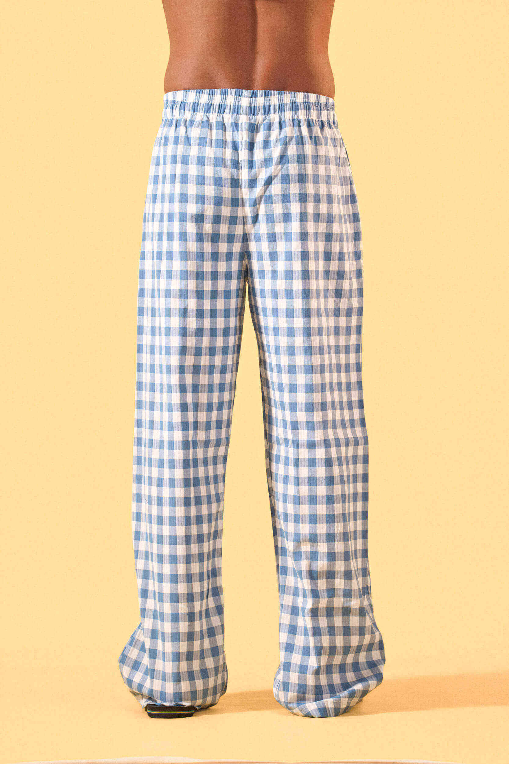 a man wearing a blue and white checkered lounge pants