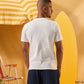 a male wearing  an off white t-shirt with buttons at the top that is a ribbed material 