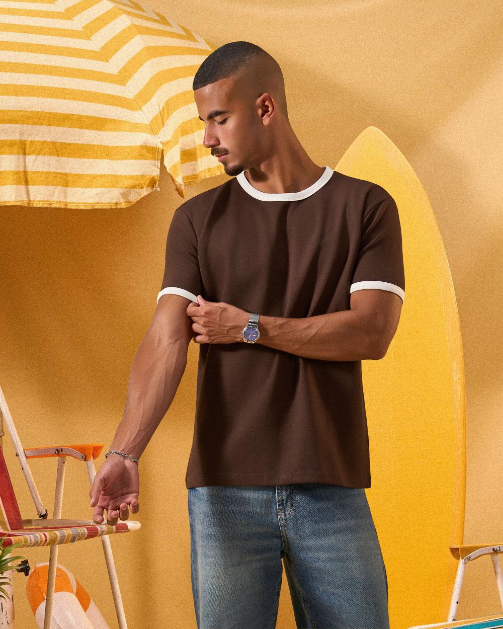 a man wearing a brown  t-shirt with contrast white neckline and sleeve trim 