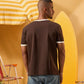 a man wearing a brown  t-shirt with contrast white neckline and sleeve trim 