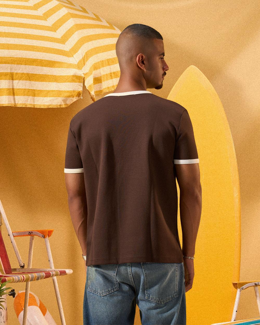 a man wearing a brown  t-shirt with contrast white neckline and sleeve trim 