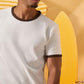 a man wearing an off-white t-shirt with a contrast brown neckline and sleeve trim 