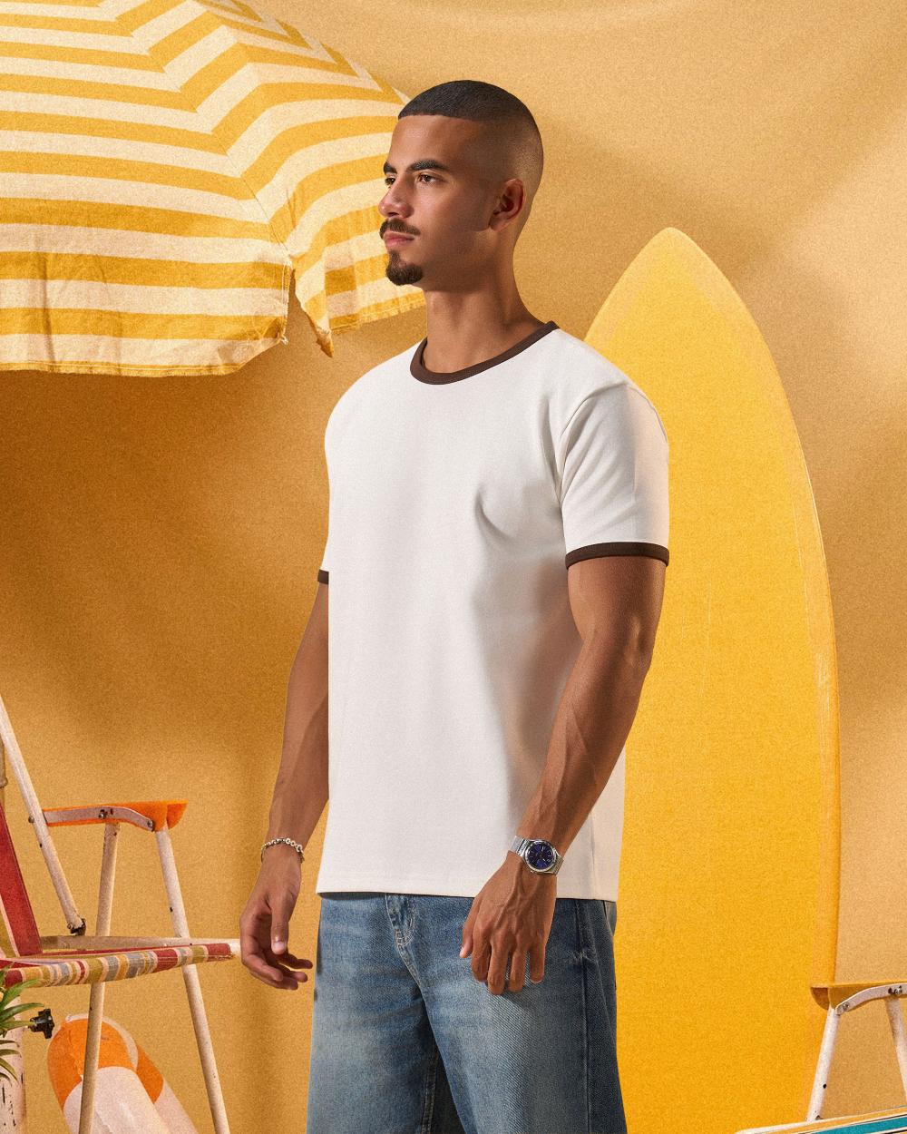 a man wearing an off-white t-shirt with a contrast brown neckline and sleeve trim 