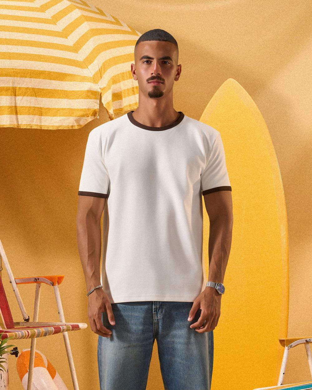 a man wearing an off-white t-shirt with a contrast brown neckline and sleeve trim 
