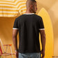 a man wearing a black  t-shirt with contrast white neckline and sleeve trim 