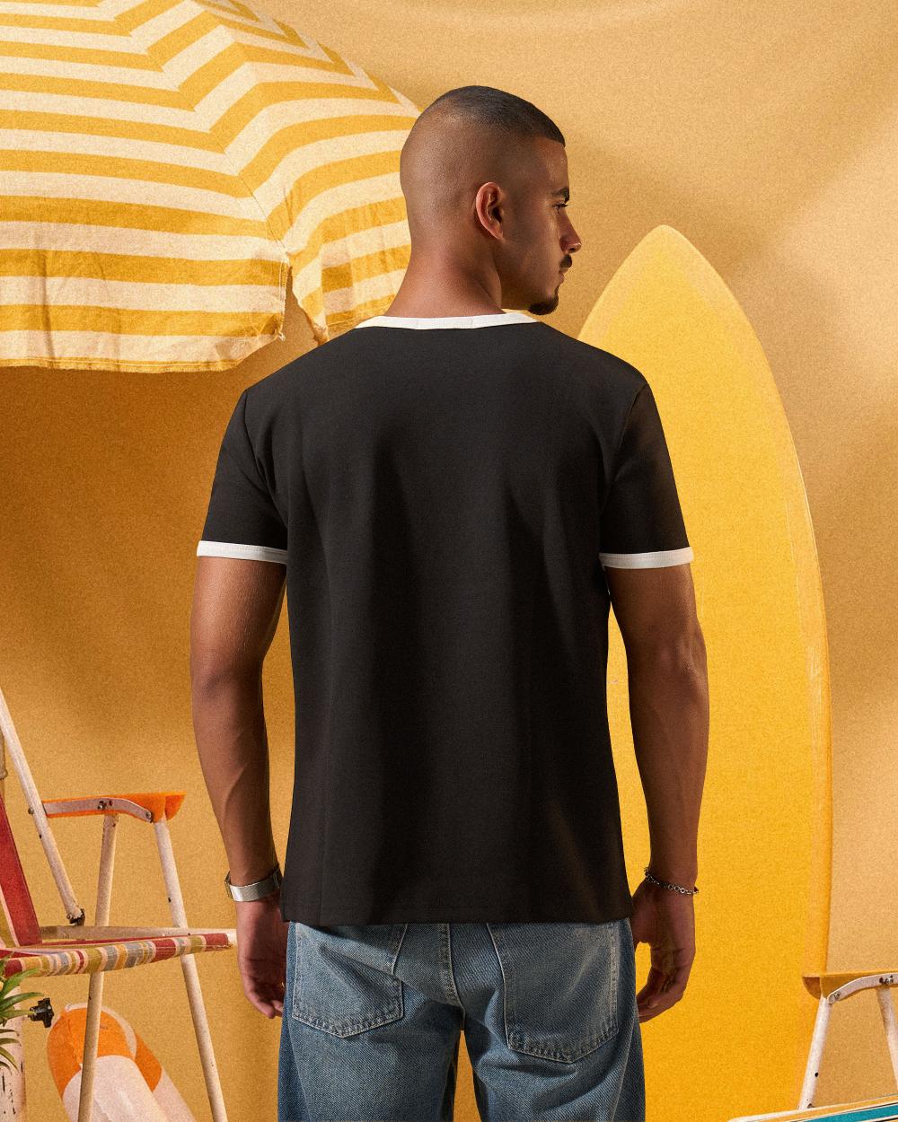 a man wearing a black  t-shirt with contrast white neckline and sleeve trim 